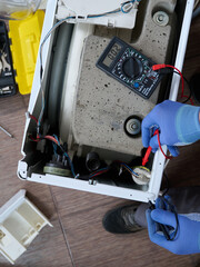 A specialist tests with digital multimeter the integrity of the circuits and the functionality of individual components.