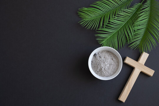 Cross, palms and bowl of ashes on black background