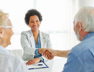 Obraz premium Portrait of a businesswoman or real estate agent or doctor shaking hands and signing a deal contract with senior couple in his office