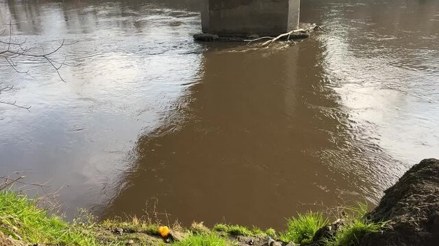 muddy river flows slowly. View from a high bank.