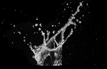 A dynamic capture of water in motion, forming a splash with droplets suspended in the air. The image emphasizes the fluidity and energy of water