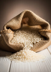Unbleached jute sack spilling raw rice grains on wooden table natural texture