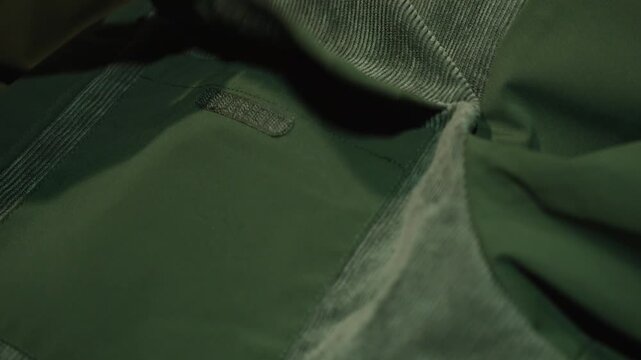 Macro view of hook and loop fastener peeling away from fabric with loud cracking sound