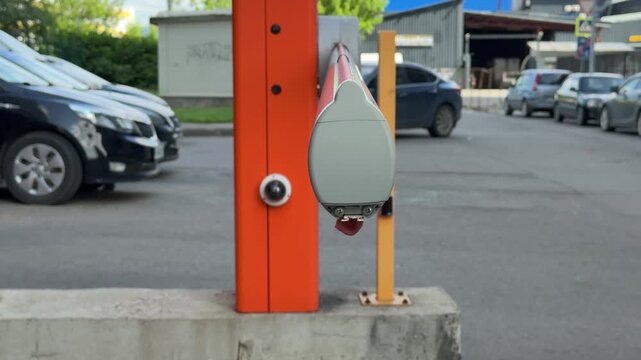 A close-up of bright, colorful barriers for parking cars, demonstrating modern urban infrastructure. A detailed overview of the orange-silver barrier mechanism.