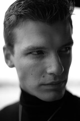 Obraz premium Confident man BW portrait outdoors in natural light, part 3. Confident young male model photographed outdoors in natural light. Black and White with expressive face.