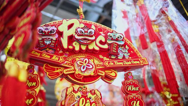 Colorful red and golden decorative elements sold on an vietnamese street market prior to the Tet holiday or Lunar new year in Vietnam, Asia. Selective focus close up video.