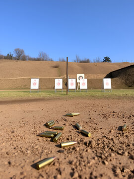 The Target Practice Setup: A shooting range with targets and empty cartridges scattered on the ground.