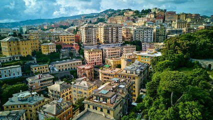 Obraz premium Drone view of residential architecture in Genoa, Italy. An aerial shot capturing the texture and colors of apartment buildings on the hillside.