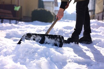 Man removing snow with shovel outdoors on winter day, closeup © New Africa