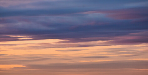 Fototapeta premium Moody twilight sky with layered purple and orange cloud streaks