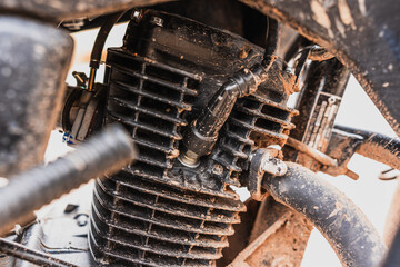 Detailed plan of parts of a black, dirty, muddy, and rusty motorcycle that is in need of maintenance.