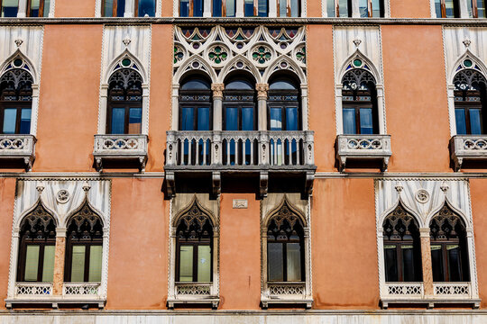 Detail of many decorated windows on a historic house in Venice