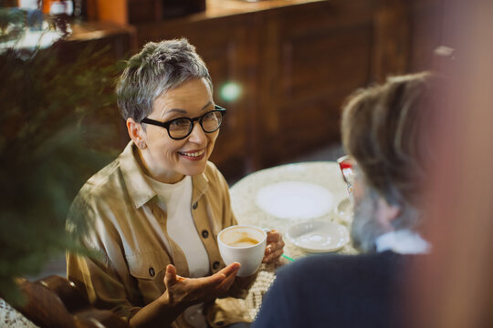 Senior woman smiling and talking during coffee date