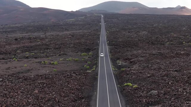 White car travels Timanfaya National Park road Lanzarote