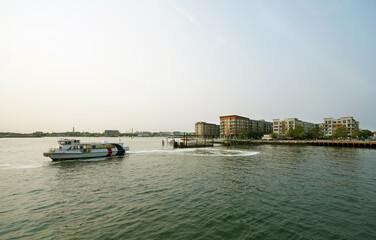 A ferry boat and new waterfront apartments in East Boston overlooking Boston Harbor with Charlestown in the distance