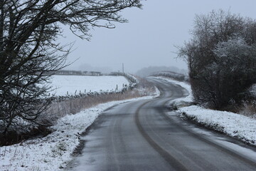 Obraz premium Road through snow covered countryside in winter