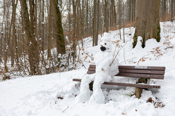 Schneemann auf der Bank sitzend