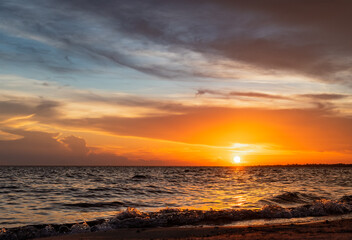 Obraz premium Serene Sunset over Rolling Waves