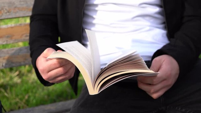 A man is flipping through the pages of a book.
