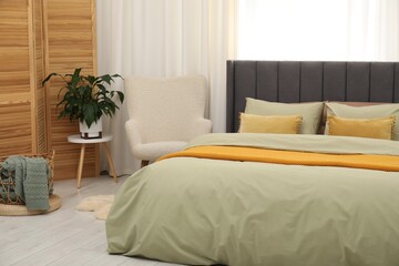 Comfortable bed with stylish linens at home, closeup