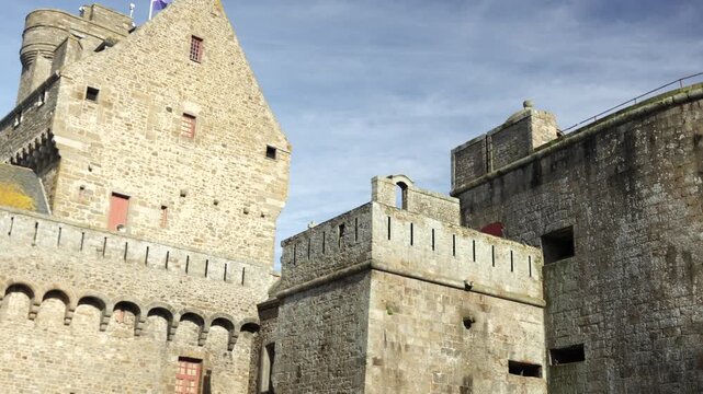 Historic stone castle and fortress walls under blue sky in Saint Malo France