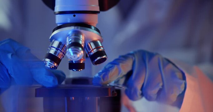 Doctor use Microscope gloved hands adjustment focus sequence showing progressive lens positioning and slide handling, Medical laboratory concept.