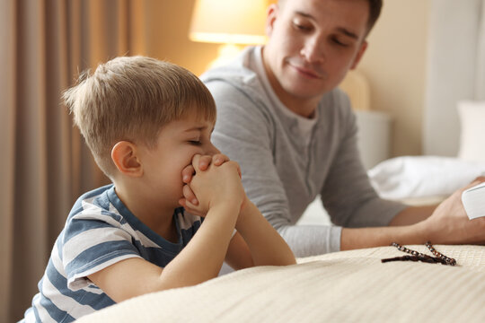 Father and his son praying at home