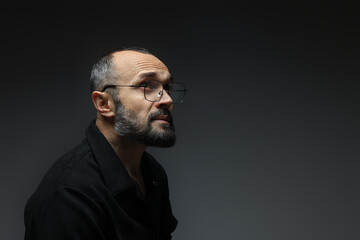 Fototapeta premium Fashion model. Handsome man in glasses on grey background, space for text