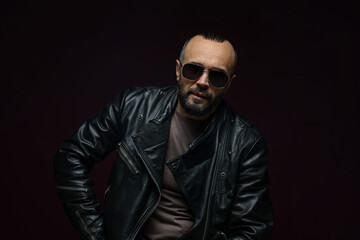 Obraz premium Fashion model. Handsome man in sunglasses on black background
