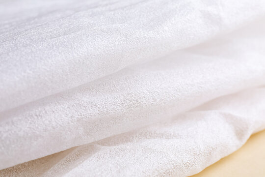 Polyethylene foam packaging on beige background, closeup