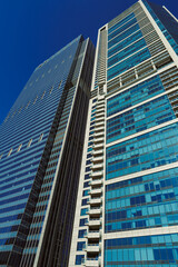 Obraz premium Tall buildings reach for the sky in an urban area during a clear day showcasing modern architecture and design