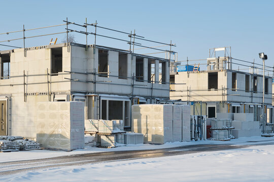 Construction site with residential houses under construction in the Netherlands on a sunny day during winter with snow under a blue sky. Concept for housing shortages and a growing population.	