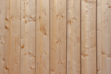 Naklejka premium Close-up view of vertical wooden planks with natural grain patterns and knots, showcasing a light-colored wood texture suitable for backgrounds or design elements