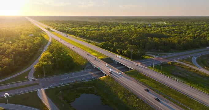 Sunset light over elevated rural freeway junction with long haul trucks and passenger cars crossing the I-75 interstate