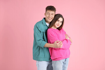 Happy couple hugging each other on pink background