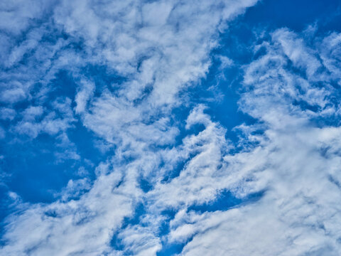A vibrant blue sky filled with a dense layer of altocumulus clouds. The rippled, scale-like texture creates a beautiful, repetitive pattern across the frame