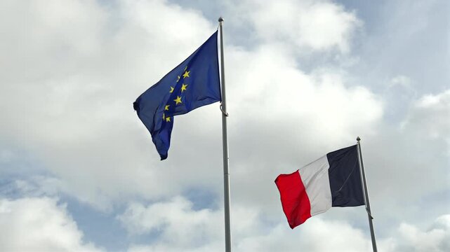 Gros plan sur le drapeau europ&eacute;en et fran&ccedil;ais qui flottent dans le vent.