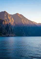 Vast cinematic panorama of colossal coastal mountains towering over a placid, deep blue sea with incredible wide-angle depth, grand, sea, travel