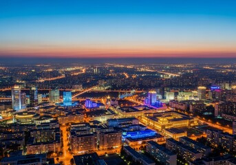 Obraz premium Ultra-wide cinematic view of a sprawling modern capital cityscape featuring illuminated cultural districts against a vast urban light horizon at twilight, structure, glass, development