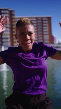 Non binary person voguing and dancing in city park