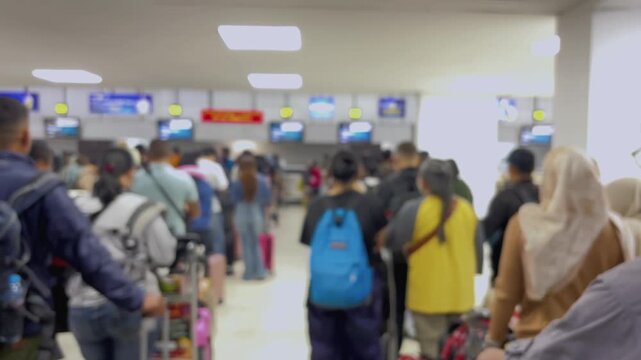 Passengers queue to board a plane at the airport terminal. Blur video.
