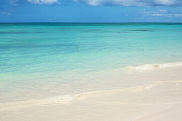 Turquoise ocean wave on clean sandy beach
