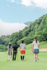 Obraz premium Male and female golfers walking on the golf course
