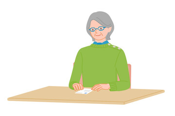 Senior woman checking postcard placed on desk
