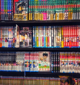 Osaka, Japan on 18 Oct 2025. Colorful Manga Books Arranged on Black Shelves Library