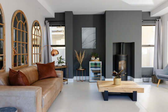 Charcoal alcove housing woodburning stove is anchoring modern lounge with low wooden coffee table