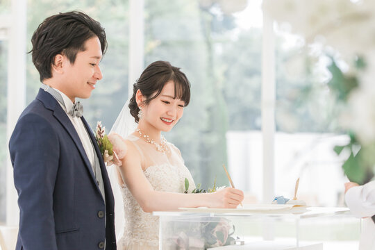 Bride and groom signing the marriage certificate and marriage vows at a wedding ceremony