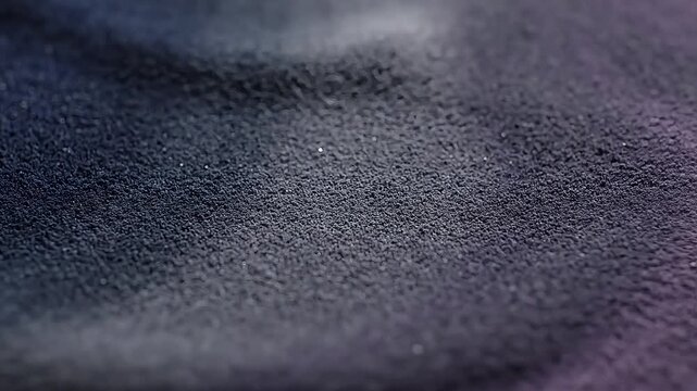 Close-up texture of dark fabric, showcasing its intricate weave and subtle sheen under soft lighting