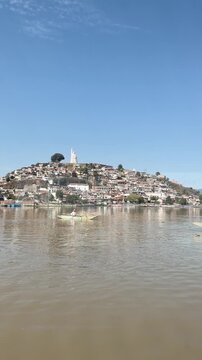 Boat arrives at scenic Janitzio Island under clear blue sky