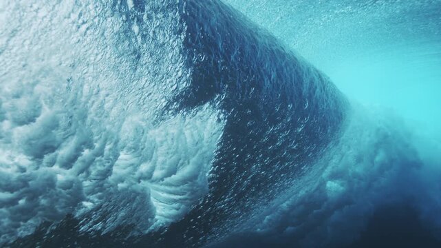 Curving underwater wave wall glowing turquoise with smooth flowing ocean texture